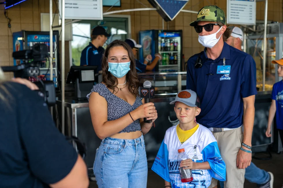 Student reporter interviewing a young Whitecaps fan