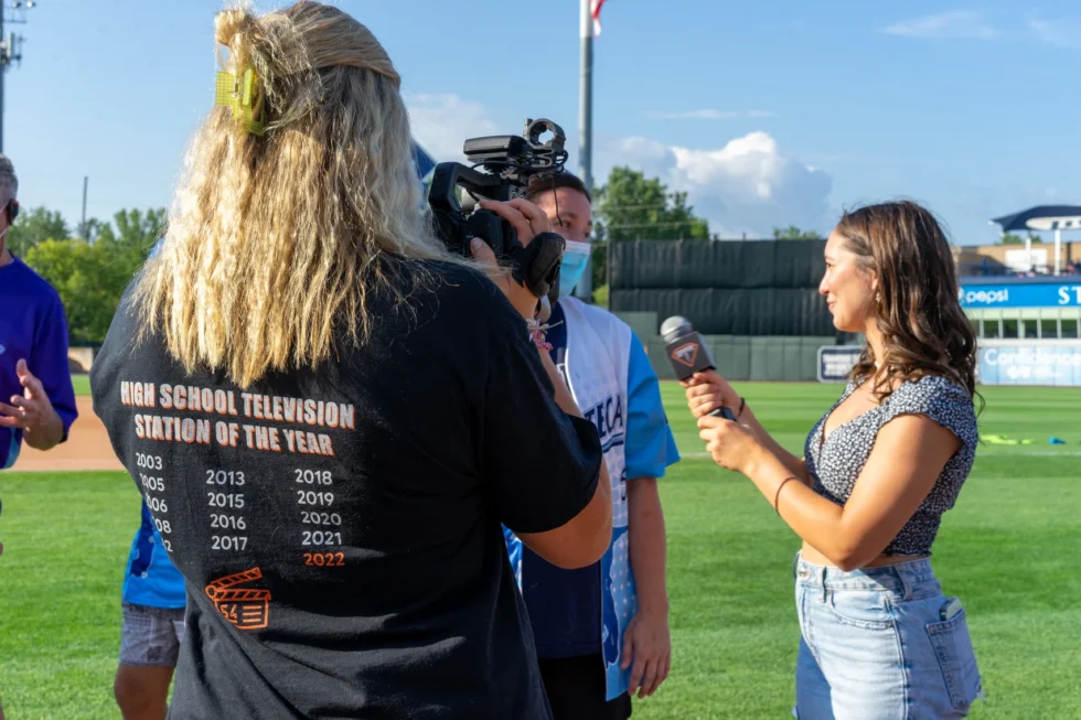 Student reporter conducting an interview on the field