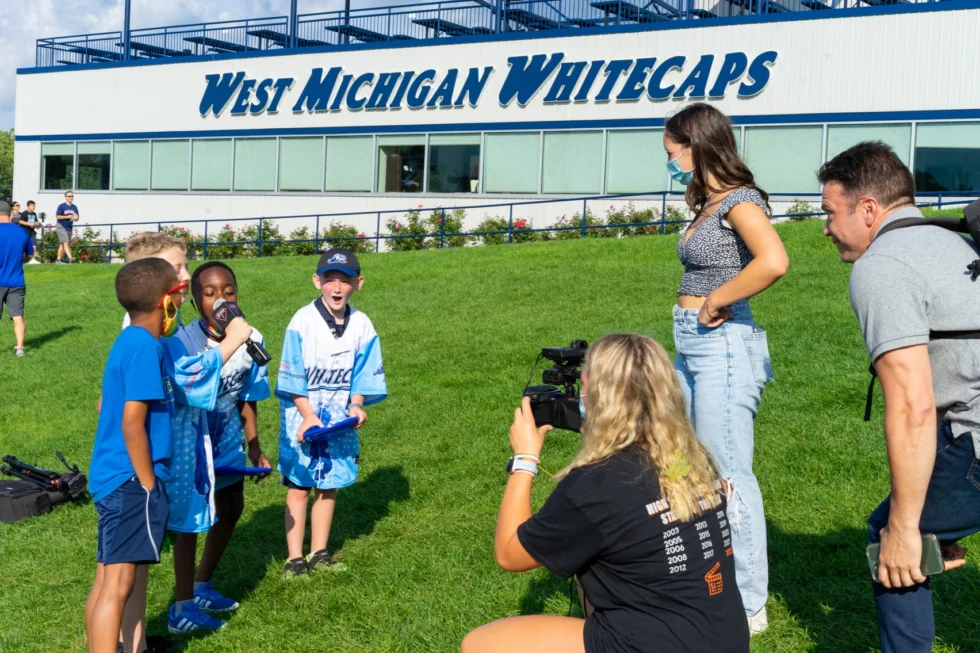 Students filming on the field at the Whitecaps ballpark