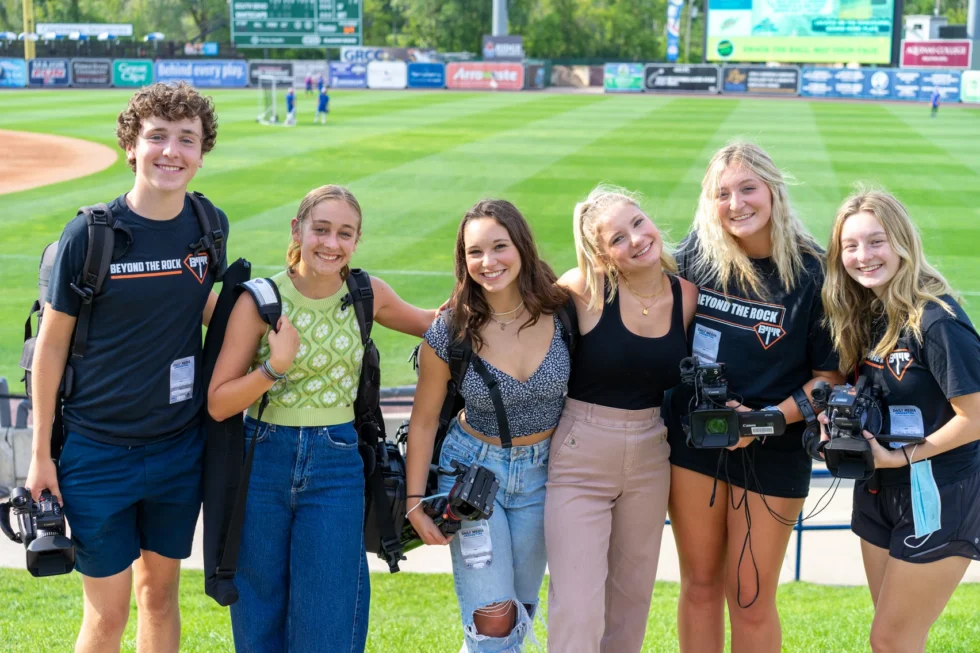 Student film crew gathered on the field